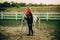 Couple walking with horse on countryside. Handsome bearded man driving horse for a bridle and looking at his girlfriend