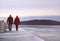 Couple walking on a long pier, by sunset on a beautiful winter day.