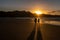 A couple walking Oneroa Beach, Waiheke Island, New Zealand in a golden sunset