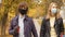 Couple walking in the park in a protective mask