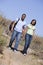 Couple walking on path holding hands and smiling