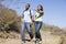 Couple walking on path holding hands and smiling