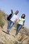 Couple walking on path holding hands and smiling