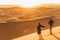 Couple walking in Sahara desert at sunset. View from behind, nature background