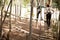 Couple walking on wooden obstacle bridge in the forest