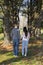 Couple walkingi among tall pine trees holding hands.