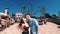 A couple walks in an amusement park. The girl and the guy jump and rejoice on the background of the slides.