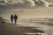 Couple walks on beach listening to music, enjoying sound of waves - canon eos 5d mark iv photo