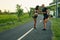 Couple Warming Up Before Running On Road. Asian Woman And Caucasian Man Doing Partner Stretching Before Jogging.