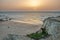 Couple watching beautiful sunset at the sandy shore of the calm Atlantic ocean