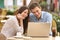 Couple watching media in a laptop in a restaurant