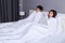 Couple watching scared movie under the blanket on bed