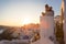 Couple watching sunrise and taking vacation photos at Santorini island, Greece.