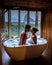 Couple watching sunset in bathtub in the bathroom during vacation in Thailand watching sunset over the ocean and