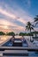 couple watching sunset in infinity pool on a luxury vacation in Thailand, man and woman watching sunset on the edge of a