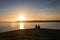 Couple watching sunset at Rhossili Bay, Wales, UK