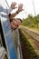 Couple waving with heads out train window