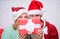 Couple wear hats as santa claus christmas tree background. Couple in love enjoy christmas celebration. It is easy to