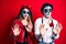 Couple wearing day of the dead costume over red moving away hands palms showing refusal and denial with afraid and disgusting