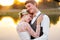 Couple in wedding attire against the backdrop of the lake at sunset, the bride and groom.