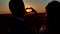 Couple wedding hands forming a heart shape with sunset silhouette. Hands-shape for the sun. Hands forming a heart shape