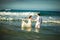 Couple in white clothes in water on beach