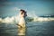 Couple in white clothes in water on beach