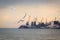 Couple of white sea gulls are flying against the backdrop of the sea port