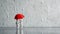 A couple of white stick figure is taking a walk while rain with a red umbrella