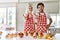 Couple of wife and husband cooking pastries at the kitchen smiling friendly offering handshake as greeting and welcoming