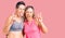 Couple of women wearing sportswear smiling with happy face winking at the camera doing victory sign with fingers