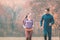 Couple in wonderful fall landscape running for better fitness