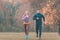 Couple in wonderful fall landscape running for better fitness