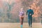 Couple in wonderful fall landscape running for better fitness