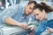 couple workers in uniform near milling machine at factory