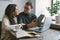 Couple working in cafe with tablet, laptop, smartphone, notepad