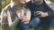 Couple wrapped in plaid sitting in park, enjoying communication, cozy atmosphere