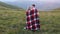 The couple wrapped in plaid stand in the meadow and enjoys each other