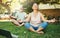Couple, yoga and lotus meditation with laptop in nature at park for mindfulness, peace and calm. Mature man, woman and