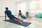 Couple of yoga students in urdhva mukha svanasana in bright studio