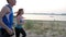 Couple of young adult athletes: woman and man running along promenade of river. Healthy lifestyle concept, slow-motion