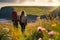 A couple of young hikers with heavy backpacks admiring scenic view of spectacular Irish nature. Breathtaking landscape of Ireland