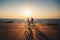 Couple of young hipsters cycling together at the beach at sunrise sky at wooden deck summer time