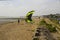 A couple of young men struggle against a stiff breeze to prepare their para glider for an afternoons sport at the Titchfield beach