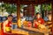 A couple of young monks sit and rest outside the temple, Thailand.