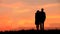 Couples as a silhouette against sunset/sunrise
