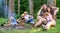 Couples or families having great time relaxing near campfire. Couples spend time outdoors on sunny day. Pleasant weekend
