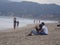 Couples immersed in love are waiting for the sunset on the beach in Santa Monica, California