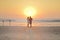 Couples walking on beach at sunset.