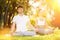 Couples Yoga, man and woman doing yoga exercises, meditate in the sunny park. Yoga outdoor. Concept of healthy lifestyle and